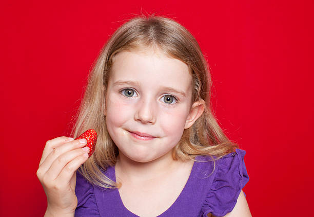 Young girl holding strawberry stock photo