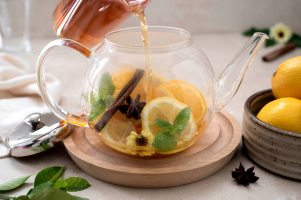 istock Glass teapot with fruit citrus tea on bright background. Herbal delicious healthy tea 1340066399