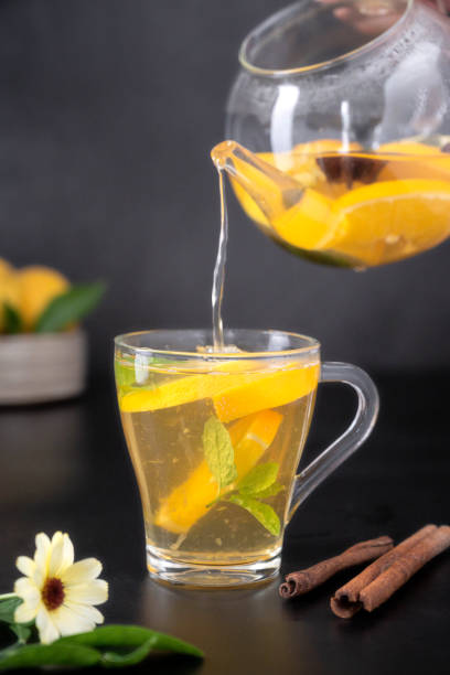 istock Glass cup with fruit herbal tea on black background. Calendula healthy tea 1340066406