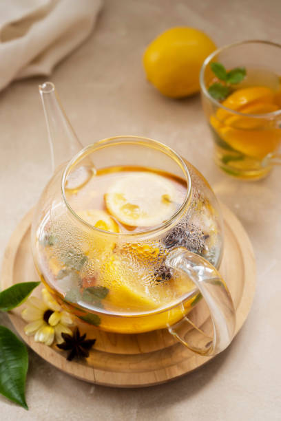 istock Glass tea pot with fruit delicious herbal tea on bright background. 1340066473