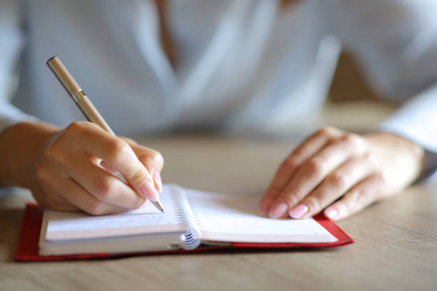 istock Woman hands handwriting on paper agenda 1340067023