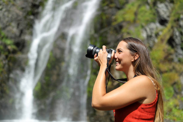 mujer tomando fotos con cámara sin espejo en la naturaleza - single lense reflex fotografías e imágenes de stock