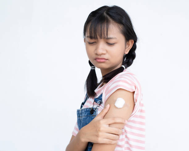 istock Young girl taking a vaccination. Virus protection.on white background. 1340067927