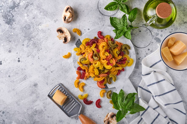 pasta. italian pasta. insalata di pasta and vegetables cooking ingredients, cheese, mushrooms and basil on old stone background. italian food cooking ingredients. top view with copy space. - cooking oil olive oil nutritional supplement spoon imagens e fotografias de stock