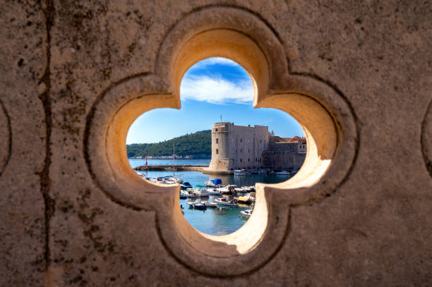 Dubrovnik harbor through feature opening in ancient wall, typically Mediterranen scene.