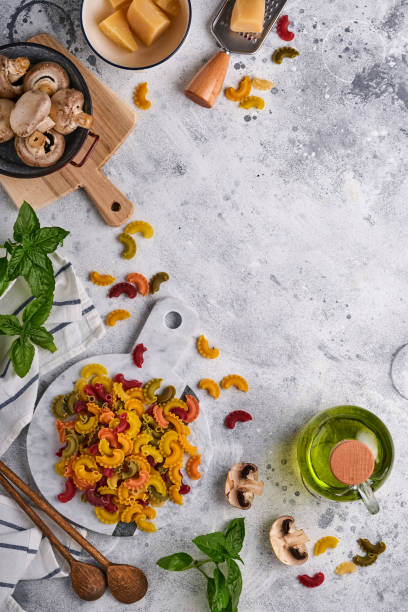 pasta. italian pasta. insalata di pasta and vegetables cooking ingredients, cheese, mushrooms and basil on old stone background. italian food cooking ingredients. top view with copy space. - cooking oil olive oil nutritional supplement spoon imagens e fotografias de stock