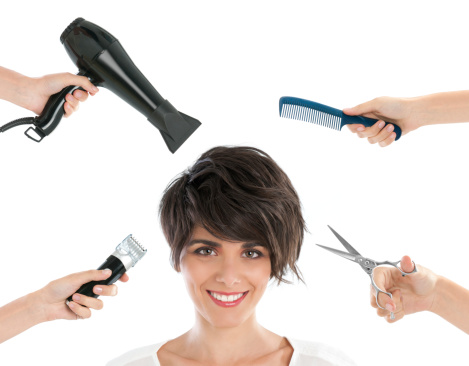 Happy smiling young woman with hairdresser tools among her isolated on white background.