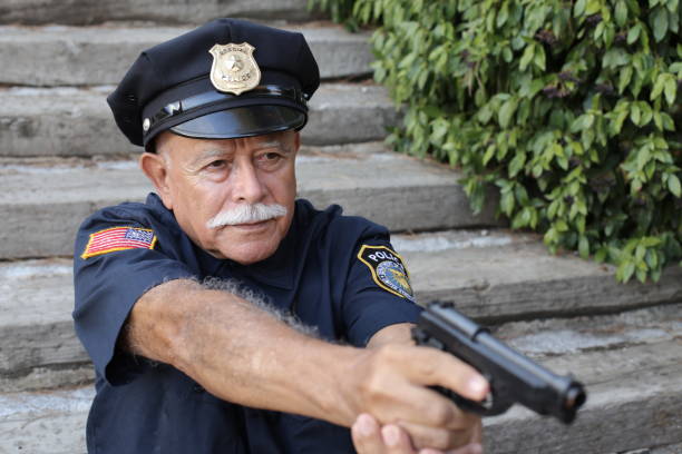 Policeman with his gun drawn. Arm Badge Create by me, Gold Chest Emblem Custom Ordered Generic. This stock image has a horizontal and outdoor composition.