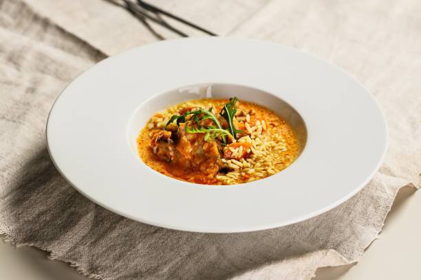 Authentic Spanish paella with cod and mussels. Traditional Mediterranean seafood dish. Baked white fish and mussels, saffron rice and vegetables. Restaurant dish serving. Close-up