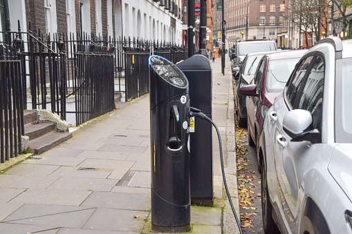 London, United Kingdom - October 12 2020: A car hooked up to an electric vehicle charging station in Central London