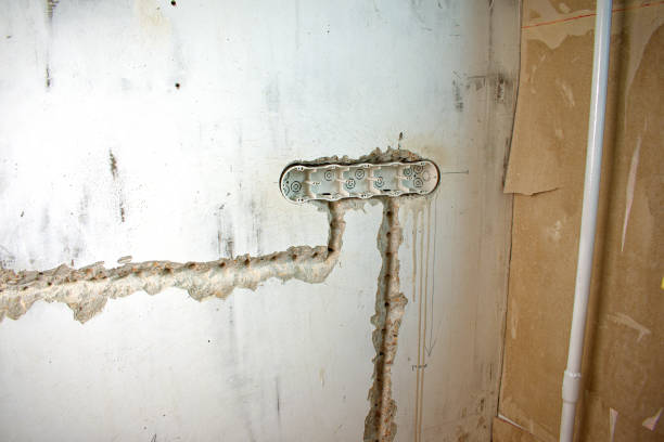 istock Installing the plastic socket box into the wall. Wiring repair and replacement concept. 1340077694