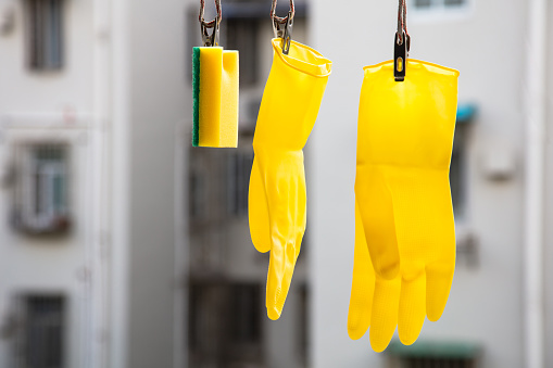 A pair of yellow rubber gloves drying outdoors