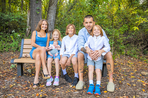 A beautiful family with children ranging from newborn to 11 years old outdoors.
