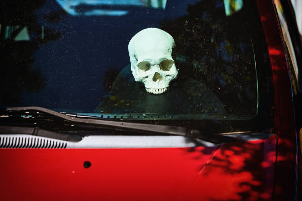 istock Road safety concept: human skull on the dashboard of a red car 1340081978