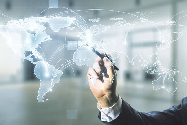 istock Man hand with pen working with abstract graphic digital world map with connections on blurred office background, globalization concept. Multiexposure 1340087544