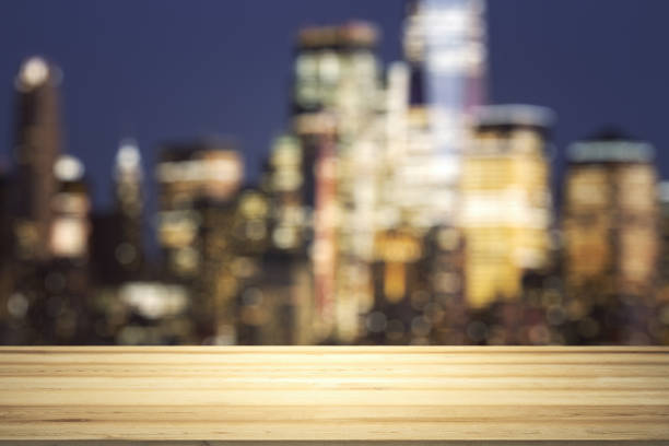 istock Empty wooden tabletop with beautiful blurry skyscrapers at evening on background, mock up 1340087715