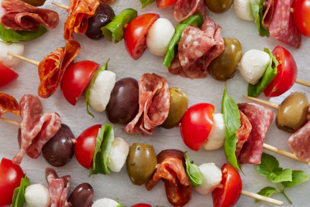Antipasto Skewers Antipasto Skewers with Mozzarella, Cherry Tomatoes, Basil, Olives and Salami antipasto stock pictures, royalty-free photos & images