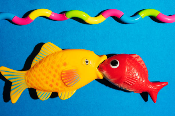 istock A creative composition of two fish biting each other and a stylized sea, waves, a minimalistic concept 1340092272