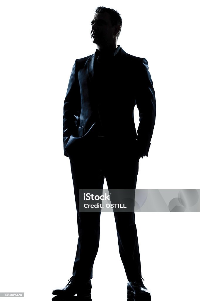Full length silhouette of businessman in suit one caucasian  business man  handsome full suit standing full length serious silhouette in studio   white background In Silhouette Stock Photo