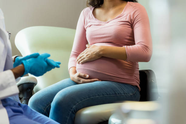 nicht erkennbarer arzt mit schutzhandschuhen bereitet sich auf die untersuchung schwangerer frauen vor - human pregnancy midwife visit healthcare and medicine stock-fotos und bilder