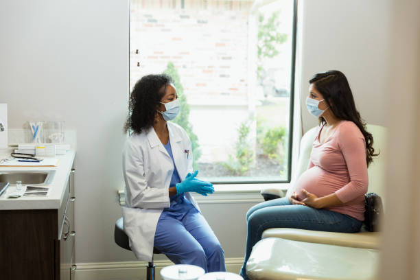 istock Doctor and patient wear protective gear during prenatal visit 1340094789