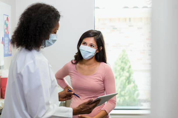 doctor and patient wear masks to slow spread of illness - human pregnancy midwife healthcare and medicine visit imagens e fotografias de stock