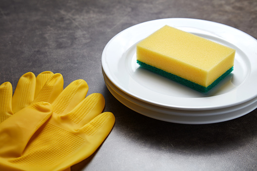 Yellow sponge for dishwashing and other domestic needs isolated on the white background