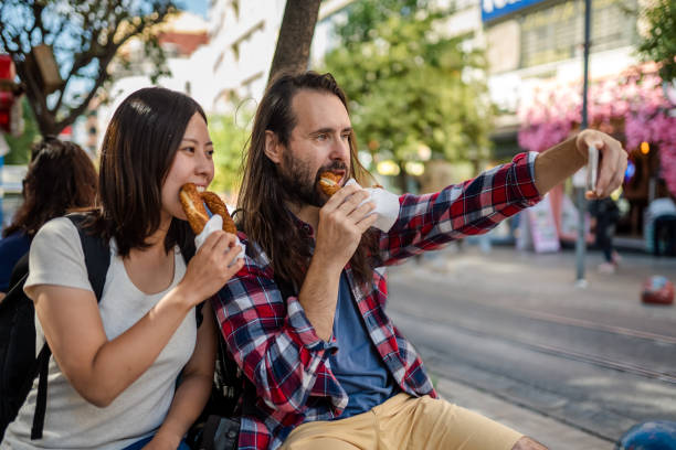 istock Multi-ethnic Couple Taking selfie while eating street food 1340097105