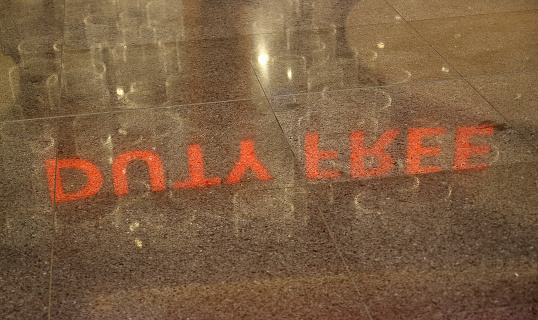 Istanbul, Turkey - October 11, 2019: mirror reflection on the floor inscription of Duty free shop at international airport. Selective focus, noise visible film grain