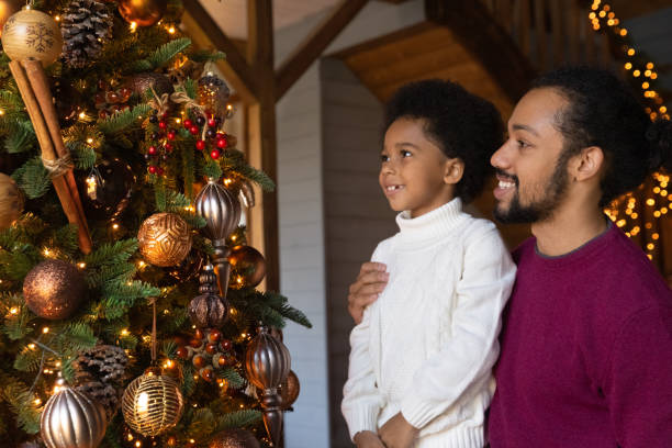 istock Happy biracial dad and son decorate fir tree 1340098458