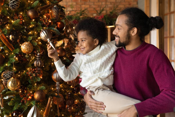 istock Happy biracial dad and son decorate fir tree 1340098467