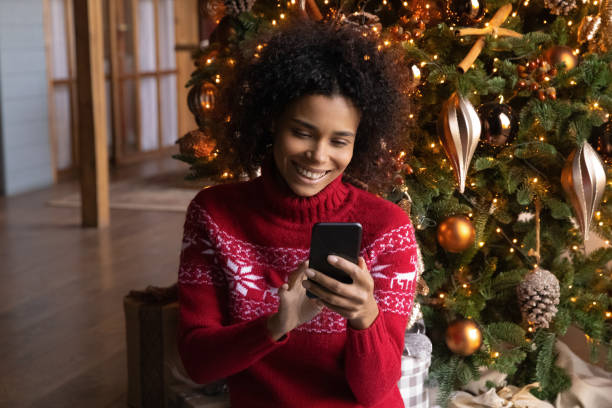 Happy biracial woman use cellphone on holidays