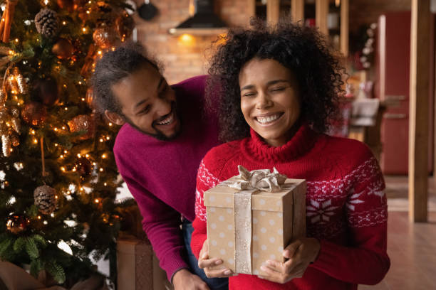 istock Happy biracial couple exchange presents on Christmas 1340098691
