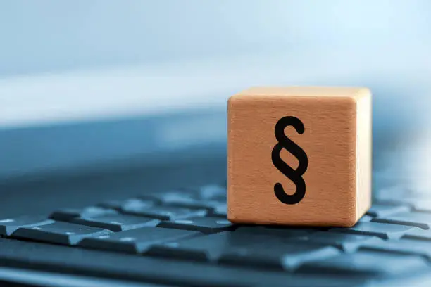 Close up of black paragraph character on wooden block on computer keyboard