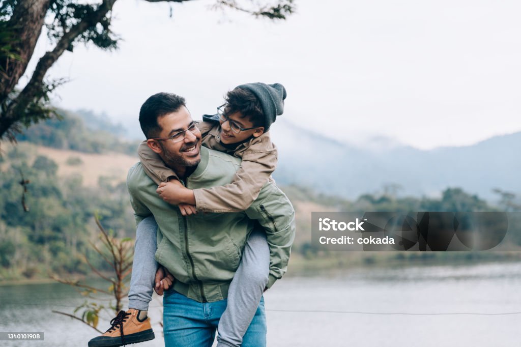 Father carrying son on his back Family Stock Photo