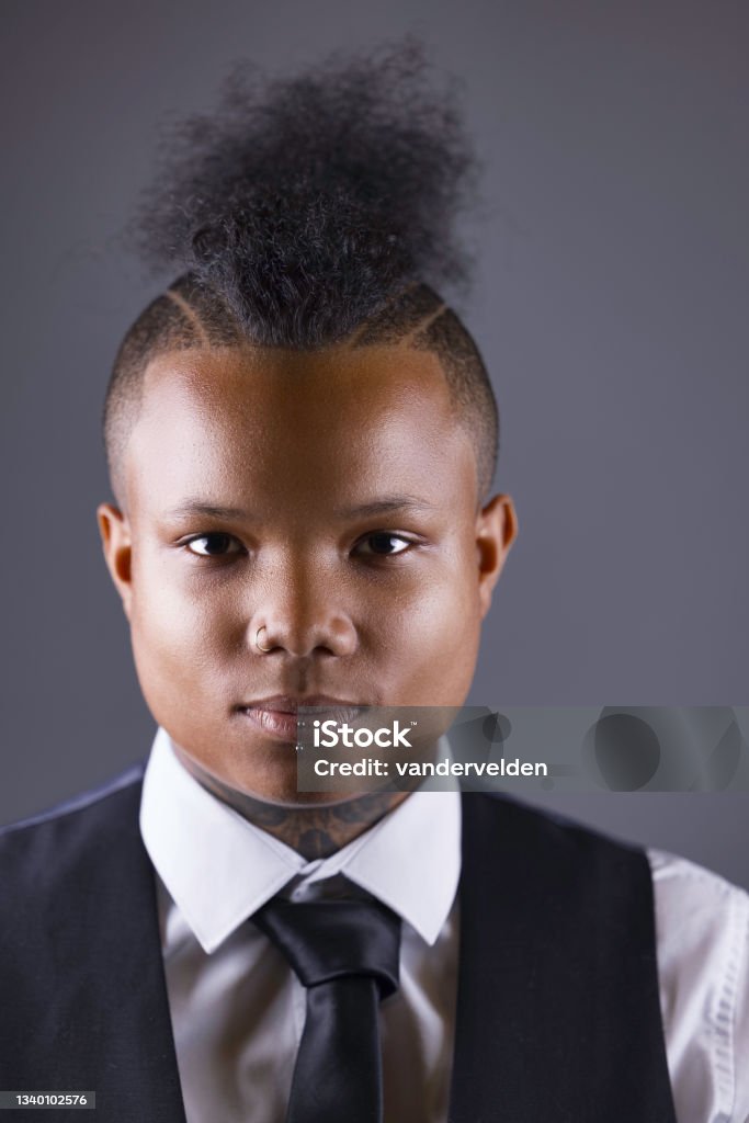 Mixed race gay lady Portrait of an androgynous gay lady with a unique hairstyle. Pierced Stock Photo