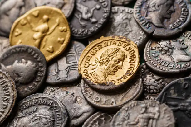 Photo of A treasure of Roman gold and silver coins.Trajan Decius. AD 249-251. AV Aureus.Ancient coin of the Roman Empire.Authentic  silver denarius, antoninianus,aureus of ancient Rome.Antikvariat.