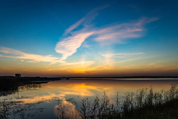 espectacular paisaje nuboso con reflejos de simetría en el agua sobre el lago al amanecer - sunrise city of sunrise water above fotografías e imágenes de stock