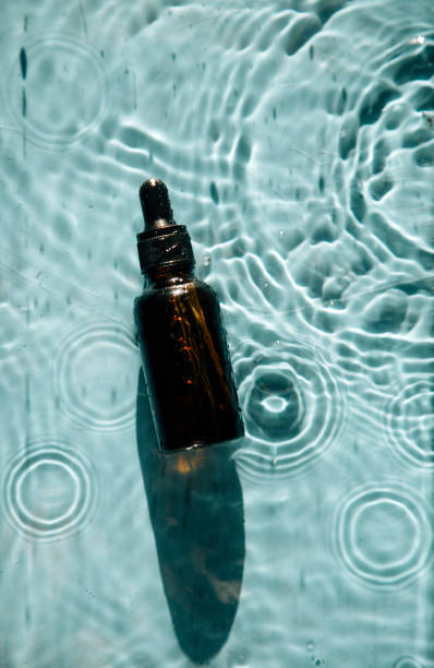 istock glass bottle with face serum on water drops 1340104974