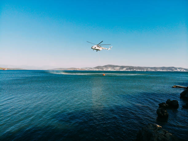 istock Aerial View Firefighting Helicopter Taking Water From the Sea 1340106838