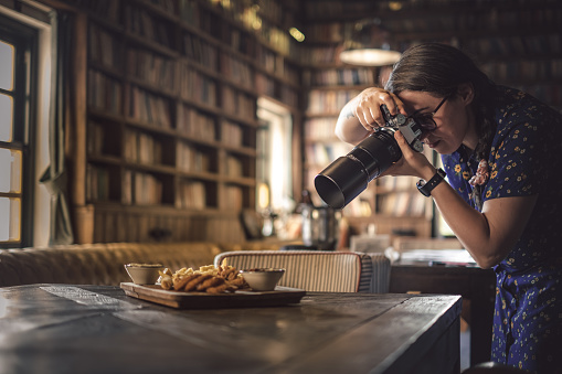 Female photographer taking photos of food in a restaurant