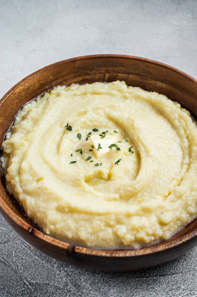 istock Boiled potato puree, Mashed potatoes  in a wooden plate. White background. Top view 1340109613