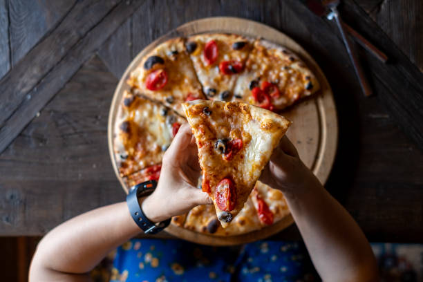 istock Hand takes a slice of pizza 1340109789