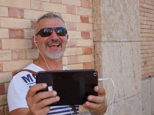 istock Middle-aged man on holiday in Altea with video conferencing tablet and sunglasses 1340109919