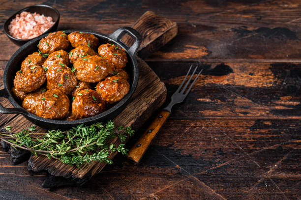 istock Meatballs in tomato sauce from beef and pork meat with thyme in rustic pan. Dark background. Top view. Copy space 1340112742