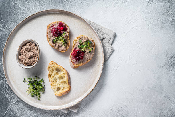 istock Toasts with chicken rillettes pate on white bread with sprouts. White background. Top View. Copy space 1340114403