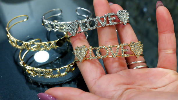 pulseras pulidas grabadas con el nombre en la mano de una mujer - chunky jewelry fotografías e imágenes de stock