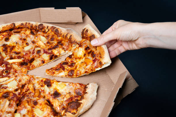 피자 상자에서 피자 한 조각을 가져 오는 손. 한 조각없이 큰 하와이 피자. 하와이 피자 에서 최고 전망. 이탈리아 음식, 길거리 음식, 패스트 푸드, 빠른 물기를위한 개념 - human hand baked food pineapple 뉴스 사진 이미지