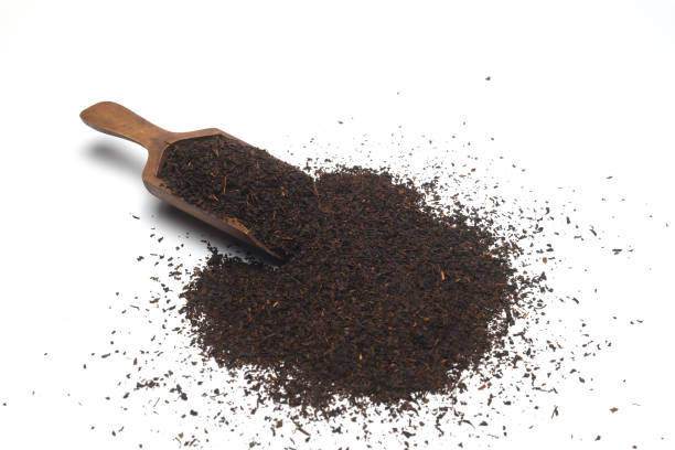 istock Dried black tea leaves in scoop isolated on white background. 1340118399