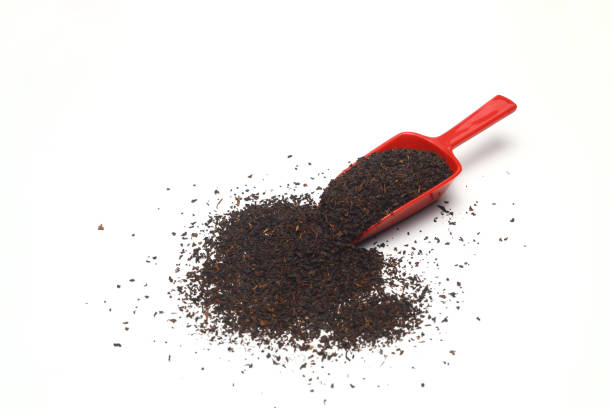 istock Dried black tea leaves in red scoop isolated on white background. 1340118426
